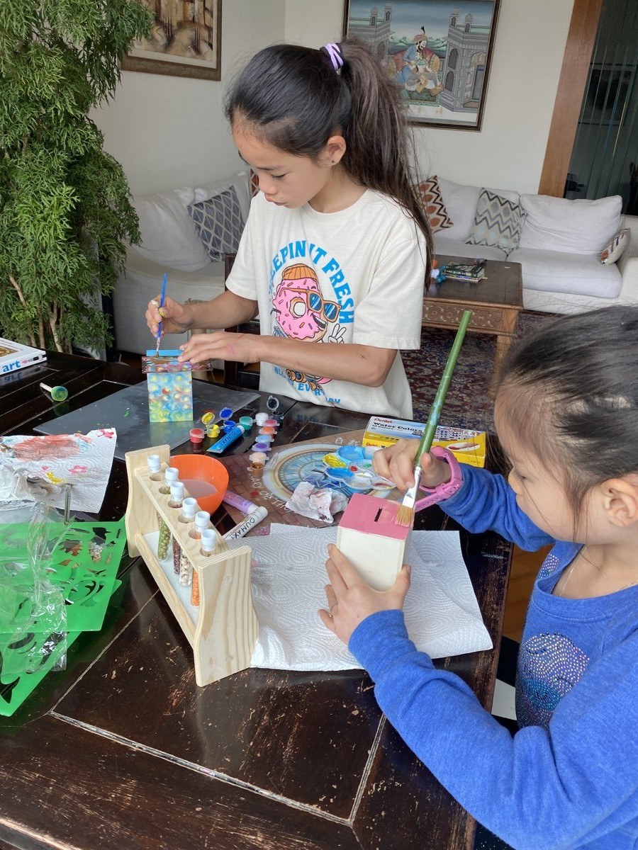 Children painting their tzedakah boxes for the Zhen Yu and the Snake craft project